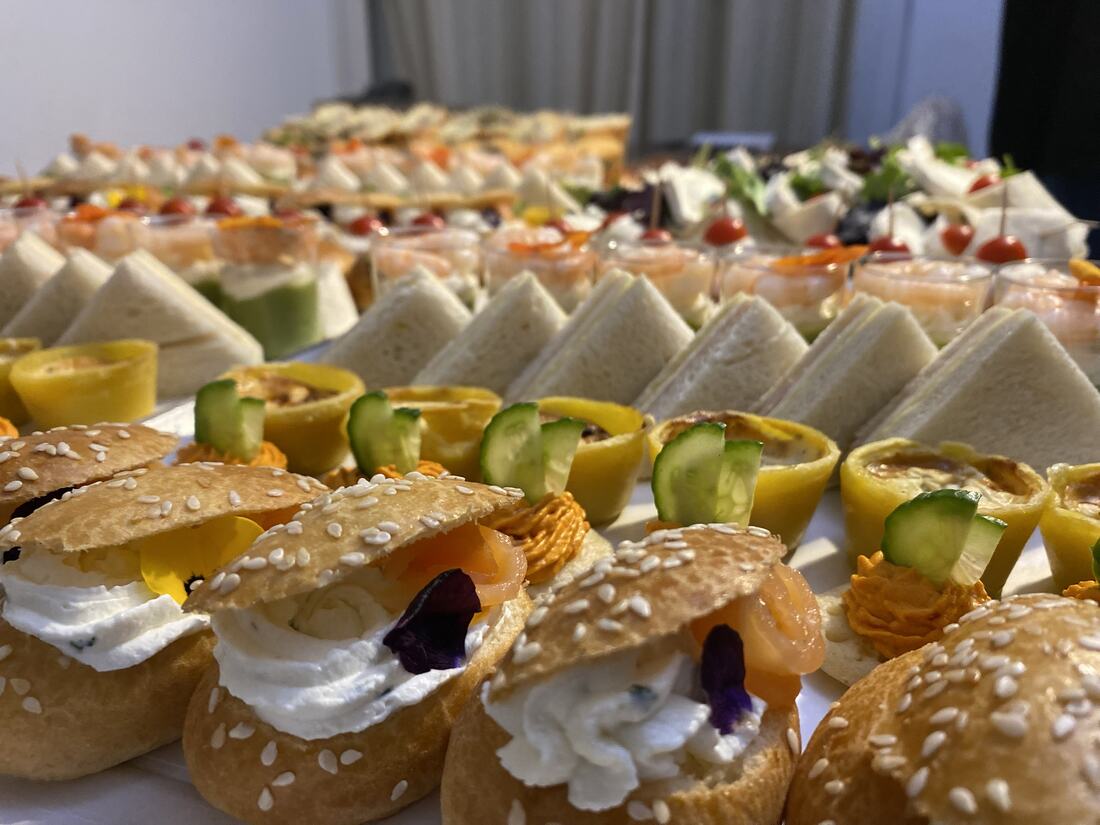 Mini-burgers briochés, quiches et roses de saumon fumé sur pain toasté, dressés en gros plan